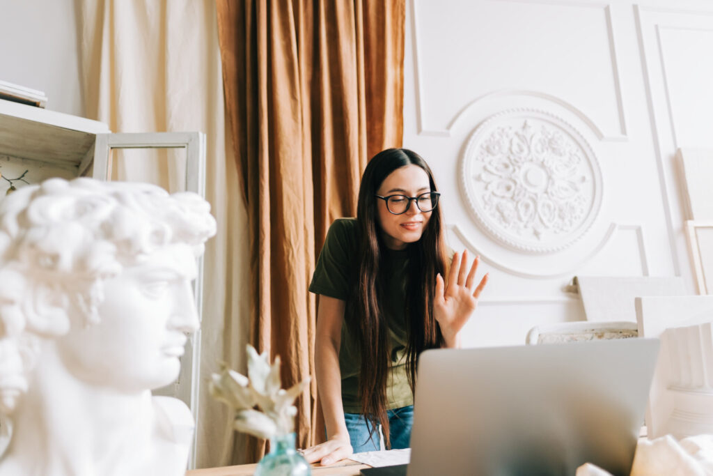 Young caucasian woman in eyeglasses video calling in app virtual chat using laptop